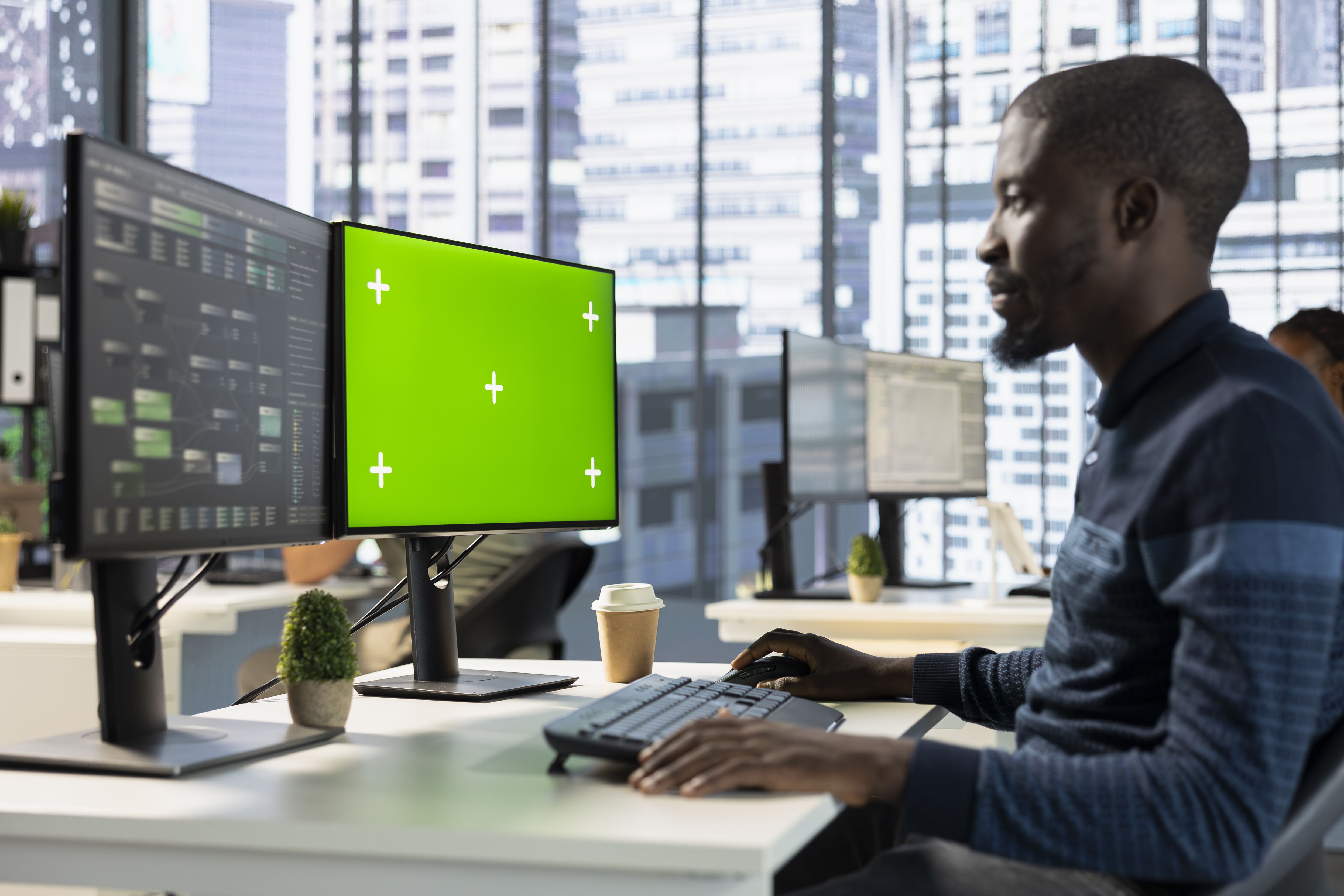Software developer working on multi-screen setup